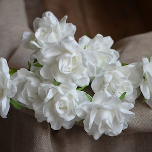 White artificial gardenia flower cluster with green leaves