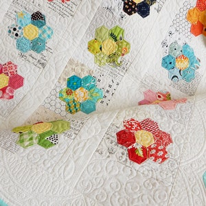 Quilt pattern for colorful hexagon flower blocks on a white quilt