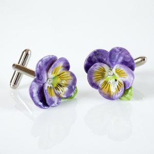 Purple pansy flower cufflinks with yellow centers and polished silver backs.