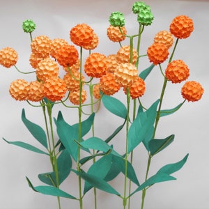 Orange paper globe flowers with green leaves and stems, small bouquet