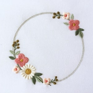Machine embroidery wreath design with dainty pink flowers and leafy circle frame