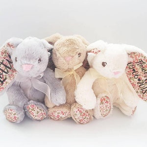 Pastel plush bunny set with lace bows, lying side by side
