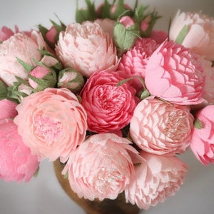 Pink paper peony flower bouquet with layered petals and green leaves