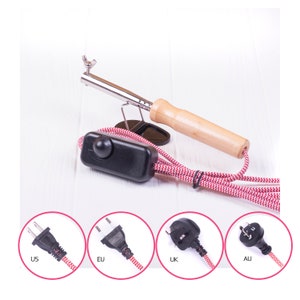 Soldering iron with brown handle and plug adapters for US, EU, UK, AU
