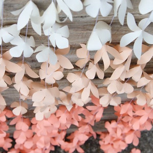 Peach ombre paper flower garland with layered cutout petals, decorative party backdrop