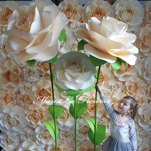 Giant paper rose flowers on stands with white and cream petals