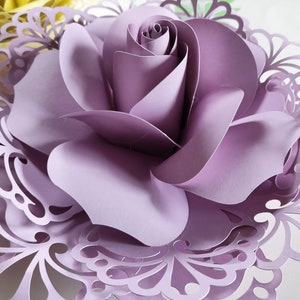 Purple layered paper flower with curled petals and lace-like paper cutout backing