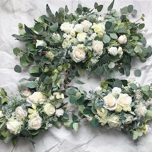 Artificial wedding arch floral arrangement with white roses and green eucalyptus leaves