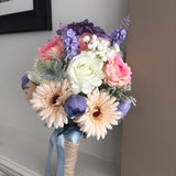 Large wedding bouquet with white rose, pink and purple blooms, blue accents, and satin ribbon wrap