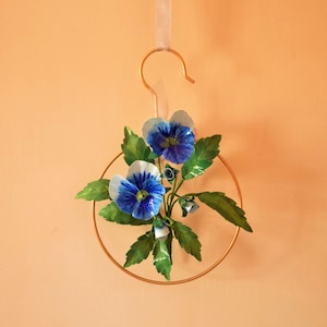 Blue and purple paper pansy flower with green leaves on a circular loop hanger