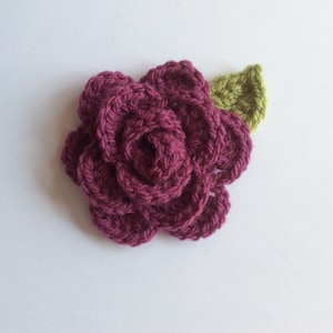 Crocheted rose and leaf applique with dark pink flower and green leaf