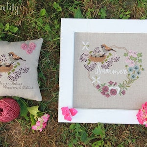 Embroidered summer garland panel with birds and flowers on light fabric, in white frame