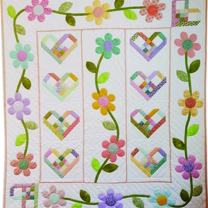 Hearts and flowers lap quilt pattern with colorful heart blocks and floral vine border