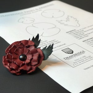 Burgundy leather poppy flower with dark bead center and layered petals