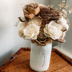 Farmhouse flower arrangement in white vase with cream and tan fabric roses and greenery