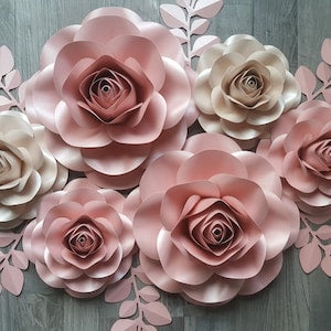 Set of layered paper rose flowers with pastel pink and beige blooms, decorative backdrop