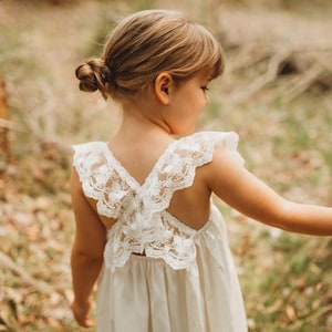 White lace flower girl dress with open-back floral bodice and short flutter sleeves