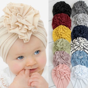 Baby turban hat in cream with a large ruffled flower detail on top