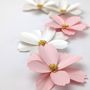 Small paper flower set with white and light pink layered petals, gold centers