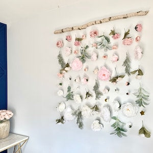 Floral wall hanging with pink and white flowers and green leaves, multiple blooms