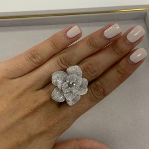 White gold diamond flower cocktail ring with pavé-set petals and round center stone