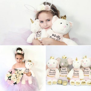 Personalized plush bunny toy with embroidered name tags, held by flower girl