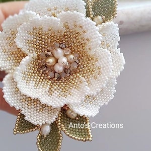 Beaded white flower with pearl center and gold bead edging