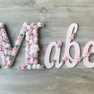 Flower letter wall sign with pink and white blooms spelling “Love”