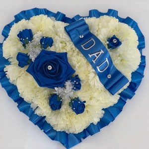 Heart-shaped artificial flower memorial wreath with blue and white blooms and ribbon