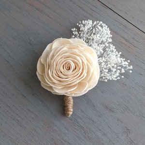 Cream sola wood rose boutonniere with white filler sprigs and wrapped stem