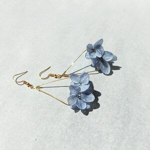 Gold teardrop earrings with blue preserved hydrangea flowers in resin