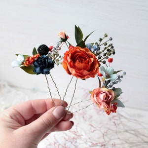Floral hair pins with orange rose, navy bloom, and greenery on delicate stems