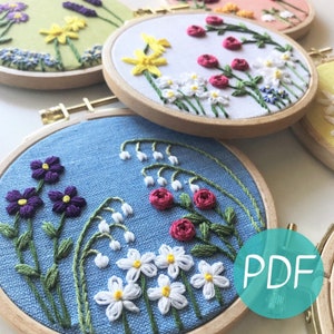 Embroidery hoop wall art with colorful flower garden stitches on blue fabric