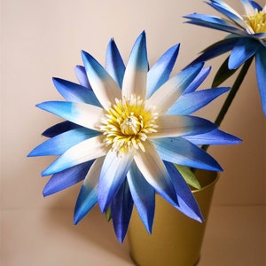 Blue and white paper water lily flower with green leaves