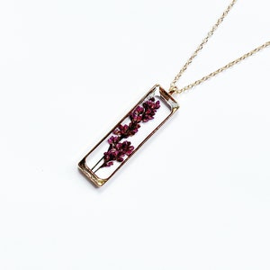Gold pressed-flower necklace with rectangular pendant and deep purple dried lavender