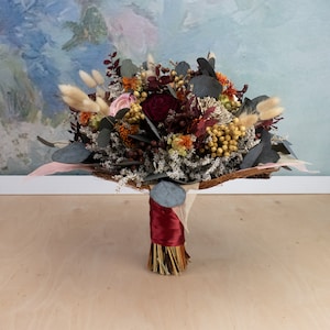 Fall sola flower wedding bouquet of dried blooms in burgundy and burnt orange with eucalyptus
