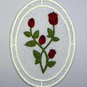 Oval machine embroidery design with red flowers and green leaves, white lace border