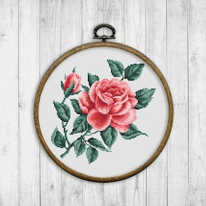 Rose floral cross stitch pattern in embroidery hoop, pink rose with green leaves