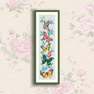 Framed cross stitch pattern with butterflies and flowers in a vertical needlepoint chart
