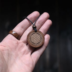 Wood pendant necklace with round flower of life design and dark cord