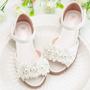 White toddler sandals with pearl flower straps and ankle hook