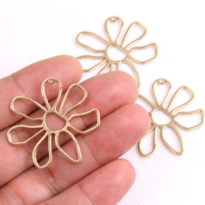 Flower-shaped brass earrings, gold-tone petal outline with loop hooks