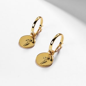 Gold huggie hoop earrings with round coin charms and small flower engraving