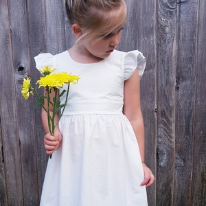 White toddler dress with ruffled cap sleeves and gathered waist, full skirt