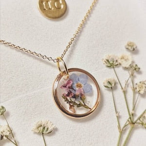 Gold plated pendant necklace with round locket and pressed forget-me-not flowers