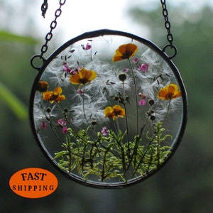 Round glass hanging frame with pressed yellow flowers and pink forget-me-nots