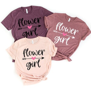 Set of three flower girl graphic T-shirts: dark purple, mauve, and light pink, “Flower girl” text