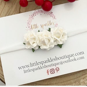 White newborn headband with clustered fabric flowers and ribbon bow detail