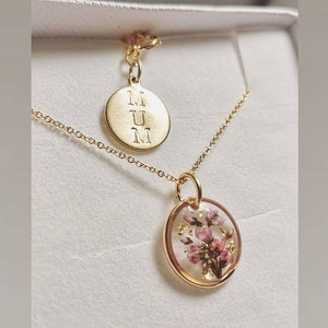 Gold plated pendant necklace with pressed flower oval locket and round charm