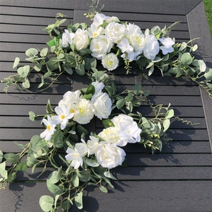Artificial floral swag for wedding arch: white roses with green eucalyptus leaves.